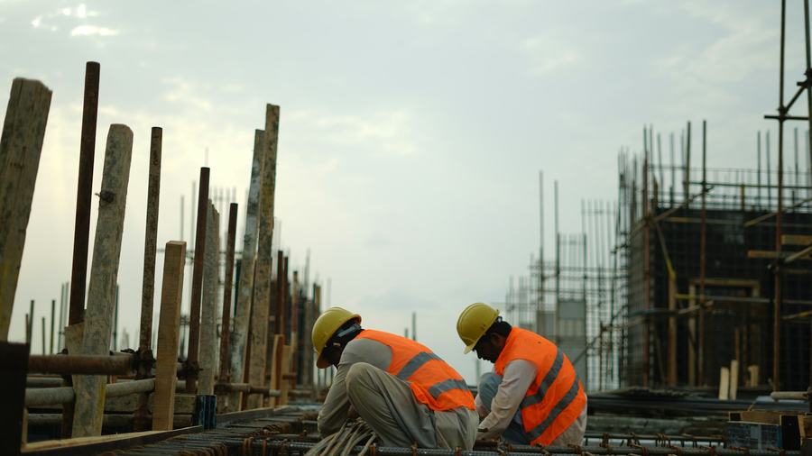 Site workers in hard hats and safety vests